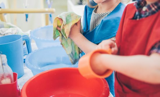 Two kids washing dishes. Montessori engaging educational activit