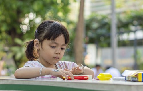 Hearing impaired children playing on the table in the park.