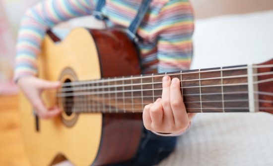 Girl Learning To Play To The Guitar