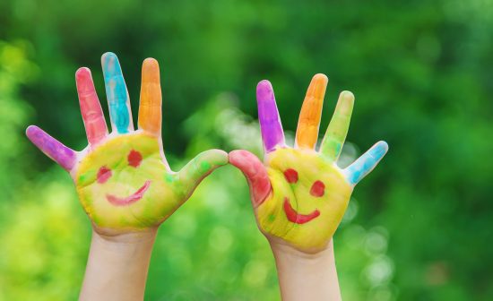 Children's hands in the colors of summer. Selective focus.