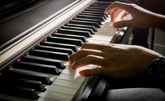 Closeup of child's hands playing the piano