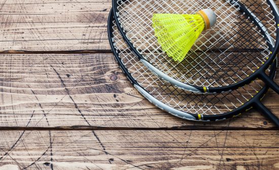 Shuttlecock and racket for playing badminton on a wooden background. Concept summer holidays.