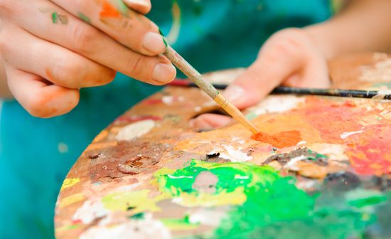 beautiful young girl draws a picture paints on art lesson